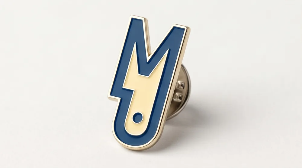 Pin metálico con el isotipo de Lumer Studio